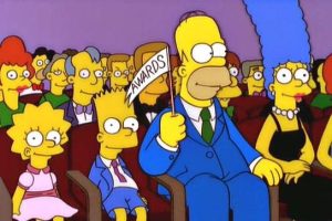 the simpsons with homer holding a makeshift white flag with awards written on it
