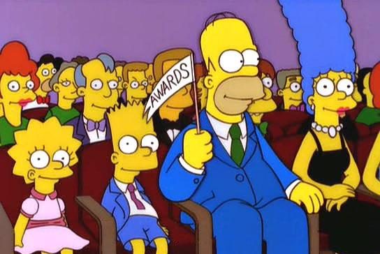 the simpsons with homer holding a makeshift white flag with awards written on it